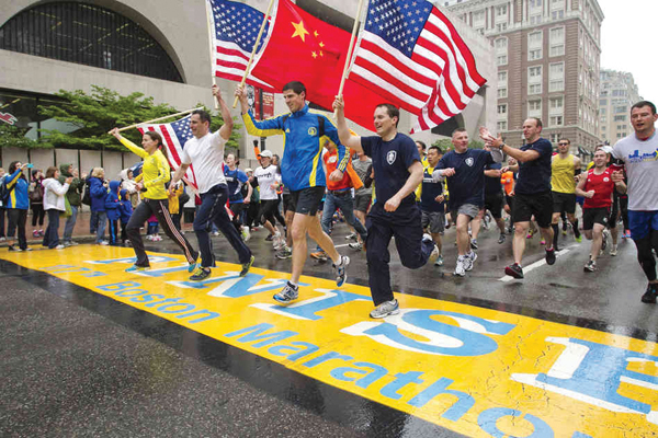 미국과 중국 국기를 든 주자들이 마지막 1마일을 완주한 후 결승선을 통과하고 있다.