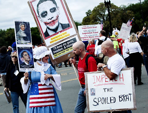 지난 12일 워싱턴에서 오바마의 정책에 반대하는 사람들이 피켓을 들고 행진을 하고 있다.