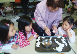 북부보스톤 한국학교에서 어린이들에게 송편 빚는 방법을 가르치고 있다