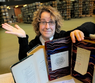 보스톤 공립 도서관의 대변인이 60년 만에 반납된 책을 보여주고 있다