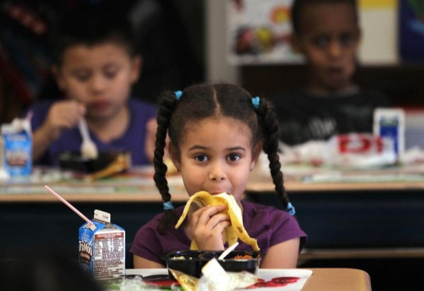 퍼킨스 초등학교의 한 학생이 책상에서 점심을 먹고 있다.