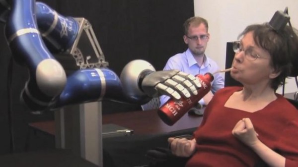 뇌졸증으로 팔과 다리가 마비된 58세의 캐시 허친슨이 로봇팔을 생각으로 조종해 물을 마시고 있다.