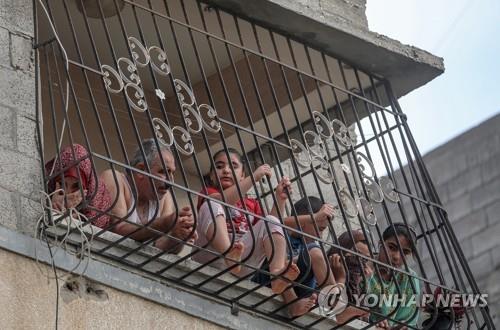 코로나19 봉쇄중에 집 밖을 내다보는 팔레스타인 일가족. 기사와직접 관련 없음.