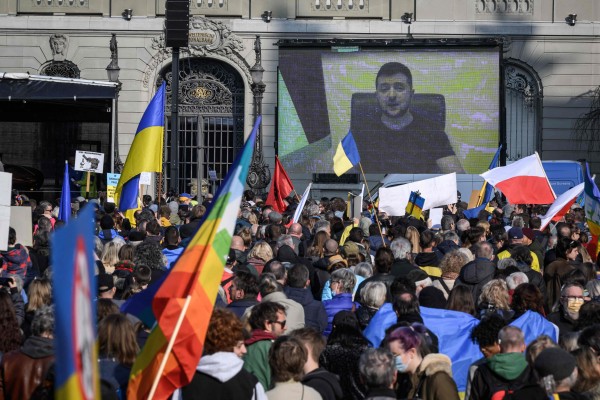볼로디미르 젤렌스키(화면) 우크라이나 대통령이 19일(현지시간 스위스 수도 베른의 의사당 앞에서 열린 반전 시위에 화상으로 참여하고 있다.
