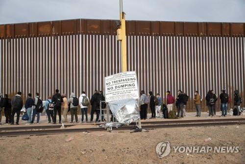 미국·멕시코 국경 장벽 앞의 이민자들