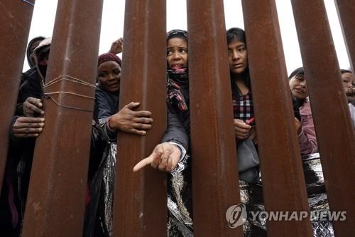 미국 국경 장벽 앞 이주민들