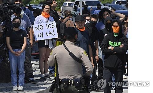 당국의 불법체류 단속에 항의하는 시위대가 미국 캘리포니아 패러마운트에서 단속원들과 대치하고 있다.