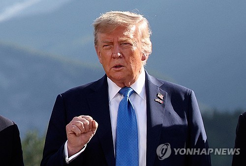 도널드 트럼프 미국 대통령이 2025년 6월 16일(현지시간) 캐나다 앨버타주 캐내내스키스에서 열린 G7 정상회의에 참석하면서 가족 사진 촬영 시간에 제스처를 취하고 있다.